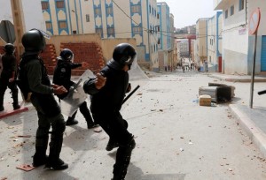 A riot policeman prepares to throw a stone towards protesters demonstrating against alleged corruption in the provincial town of Imzouren, Morocco, June 2, 2017. The clashes came after activist Nasser Zefzafi, the protest leader in the northern town of Al-Hoceima, was arrested at the start of the week and charged with threatening national security, among other offences. REUTERS/Youssef Boudlal